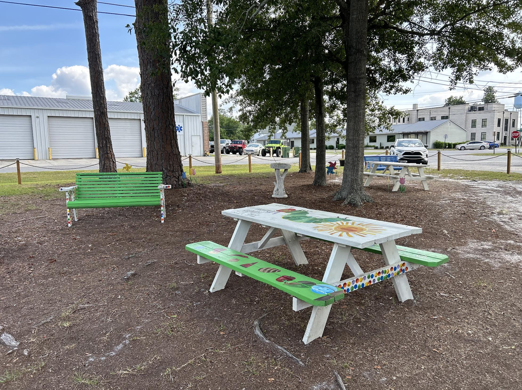 Storybook park, decorated picnic tables and benches